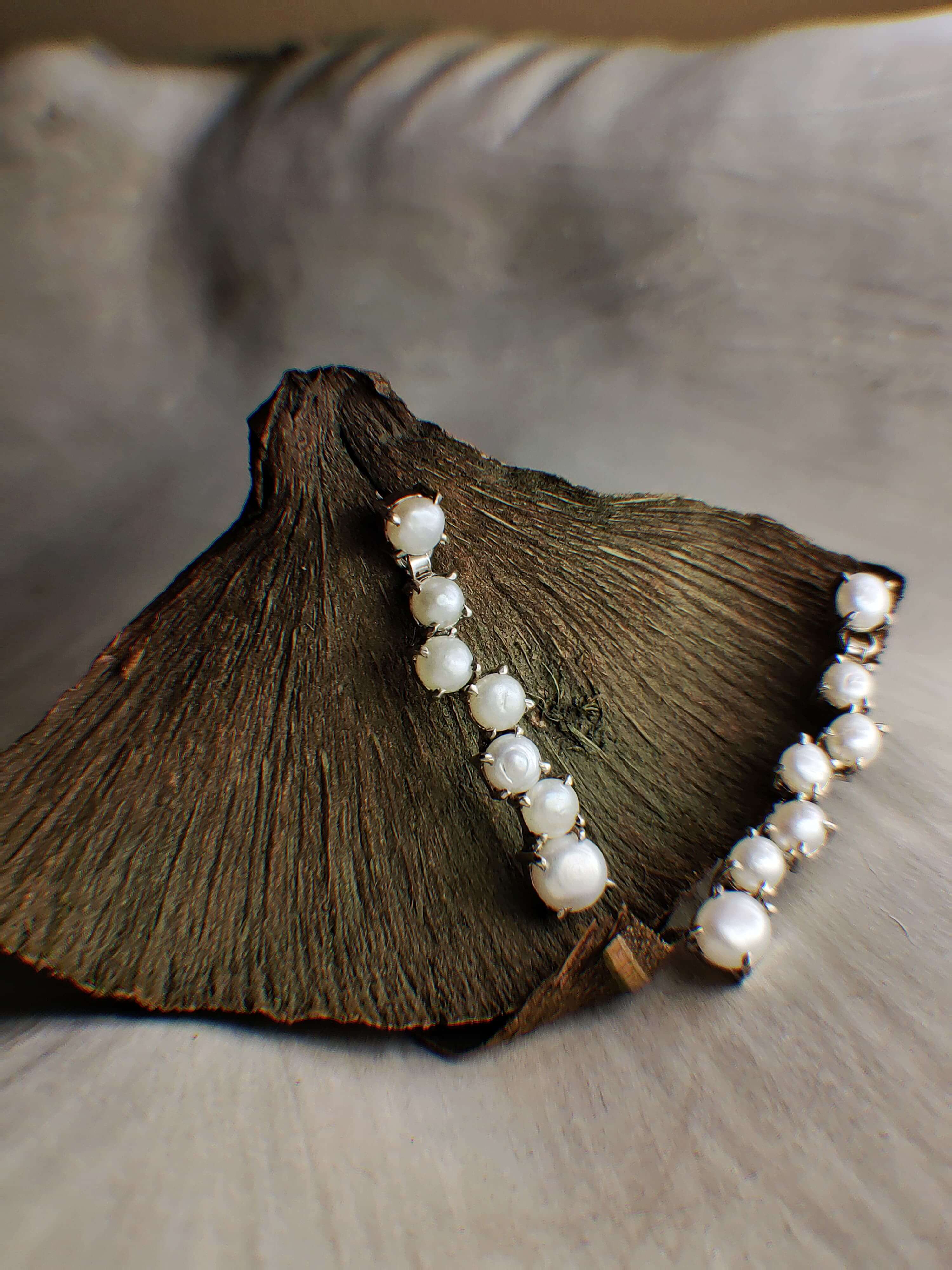 Cocooned: A handcrafted Earrings featuring Pearl and hues of White.