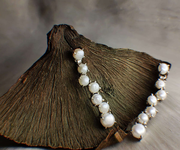 Cocooned: A handcrafted Earrings featuring Pearl and hues of White.