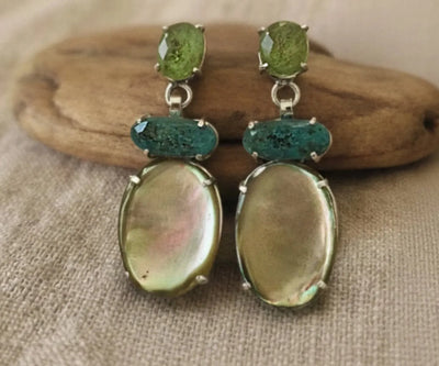 Silver Maha jewelry showing off Peridot, Tourmaline, and Mother of pearl in green, blue, and white.